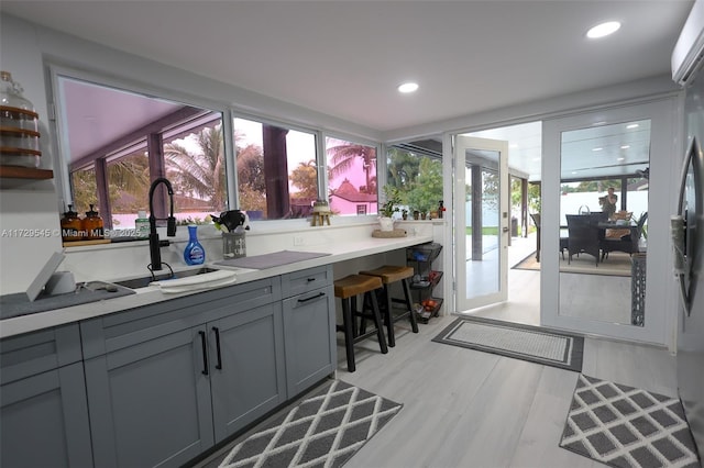 kitchen featuring a healthy amount of sunlight, recessed lighting, a sink, and gray cabinetry