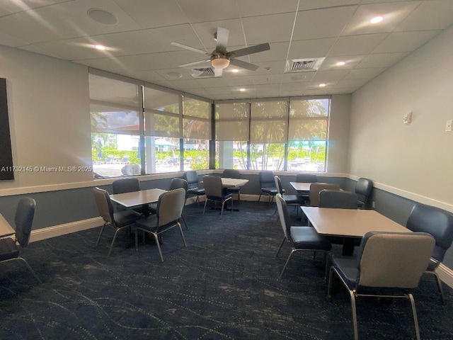 carpeted dining space featuring a paneled ceiling and ceiling fan