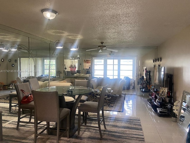 dining area featuring ceiling fan, plenty of natural light, tile patterned flooring, and a textured ceiling