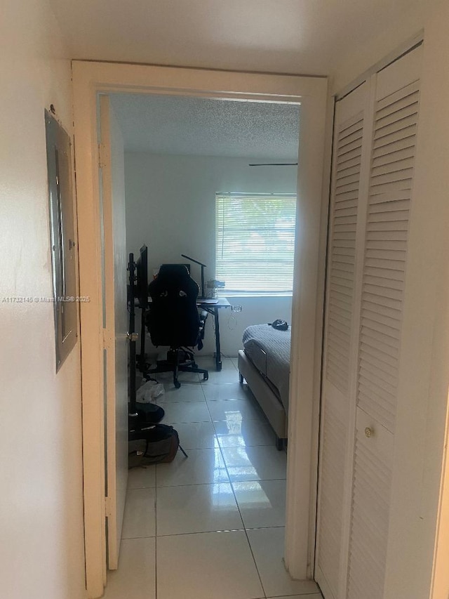 hallway featuring light tile patterned flooring and electric panel