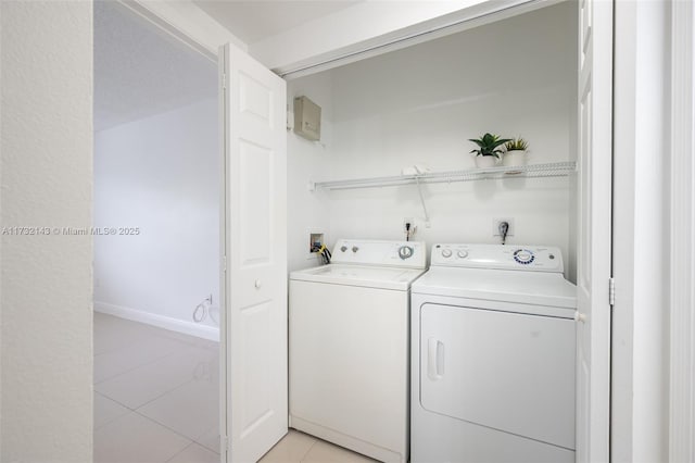 clothes washing area featuring light tile patterned flooring and independent washer and dryer