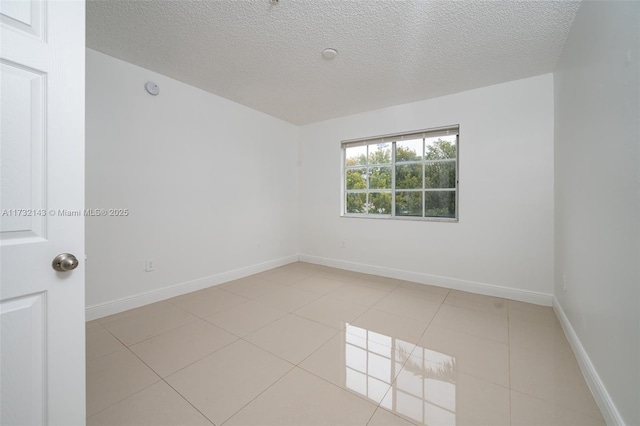 tiled spare room featuring a textured ceiling