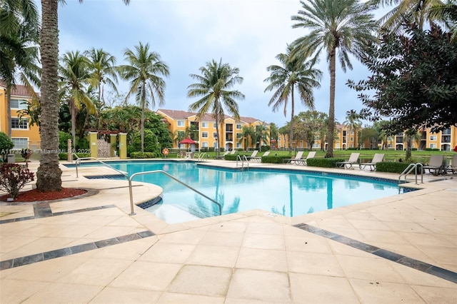 view of swimming pool featuring a hot tub and a patio