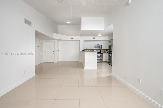 unfurnished room featuring ceiling fan, a textured ceiling, and light tile patterned flooring