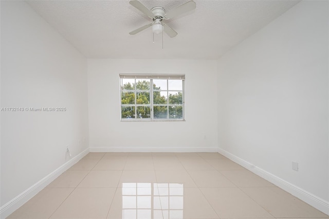 spare room featuring light tile patterned flooring, ceiling fan, and a textured ceiling