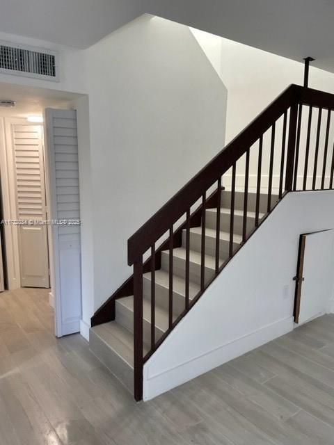 stairs with hardwood / wood-style floors