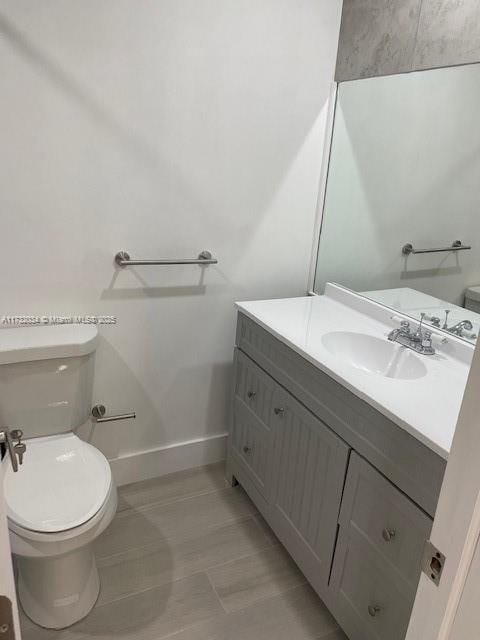 bathroom featuring tile patterned flooring, vanity, and toilet