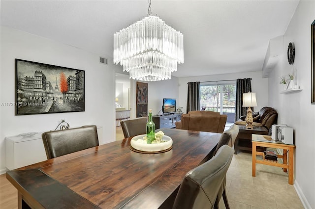 tiled dining room featuring an inviting chandelier