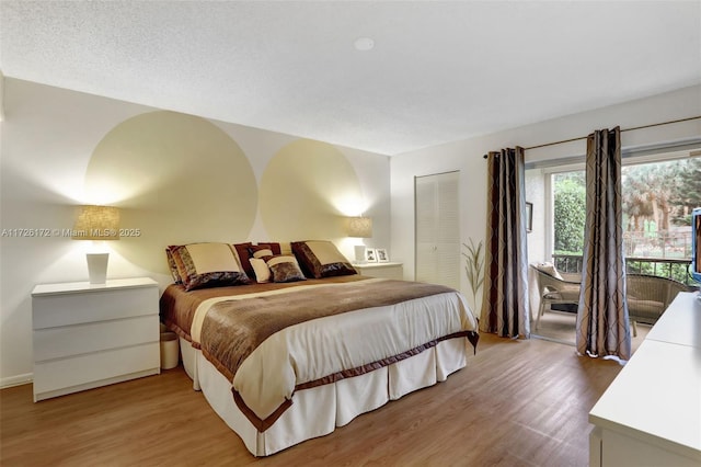 bedroom with hardwood / wood-style flooring, a closet, and a textured ceiling