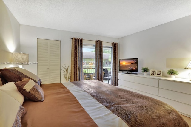 bedroom with access to exterior, a closet, and a textured ceiling