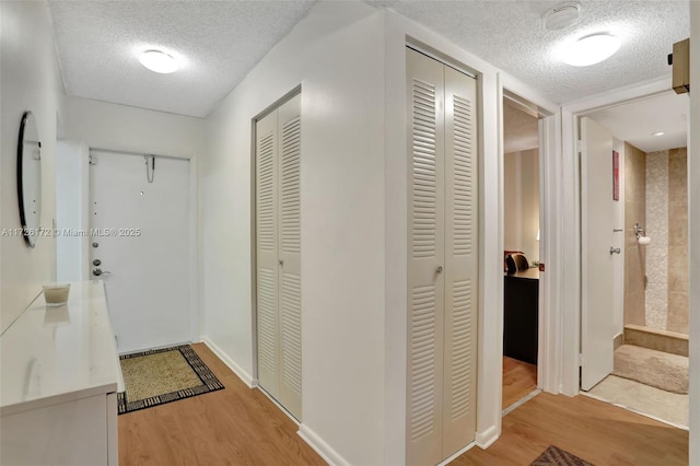 hallway with hardwood / wood-style flooring and a textured ceiling