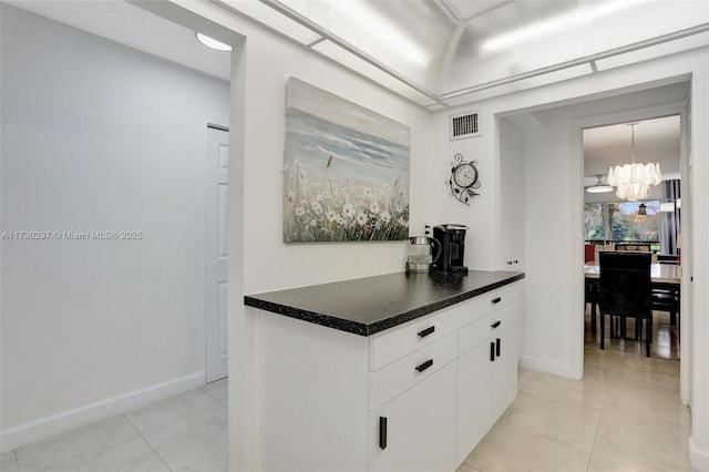 hall featuring an inviting chandelier and light tile patterned floors