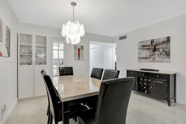 dining area with a chandelier and a textured ceiling