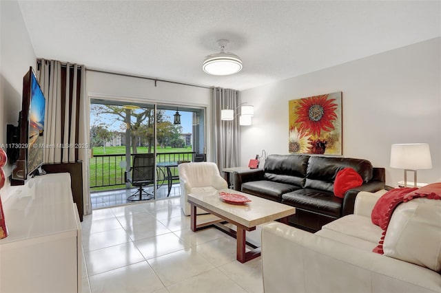 living room with a textured ceiling and light tile patterned flooring