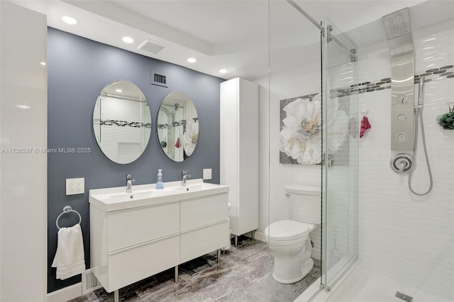 bathroom with vanity, a shower with shower door, and toilet