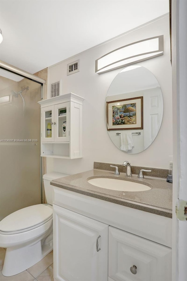 bathroom with tile patterned flooring, vanity, a shower, and toilet