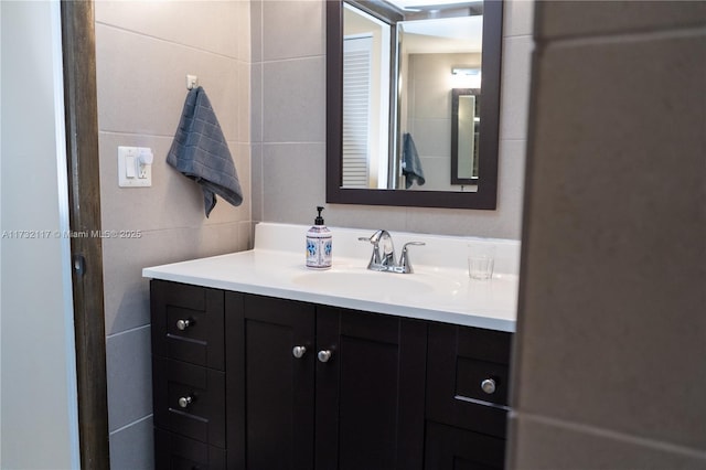 bathroom featuring vanity and tile walls