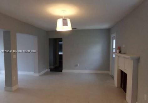 unfurnished living room with a fireplace and baseboards