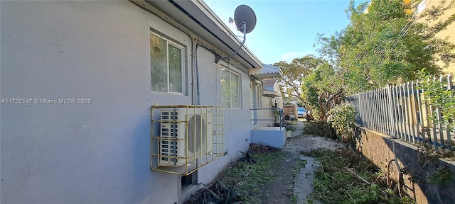 view of property exterior featuring fence and stucco siding