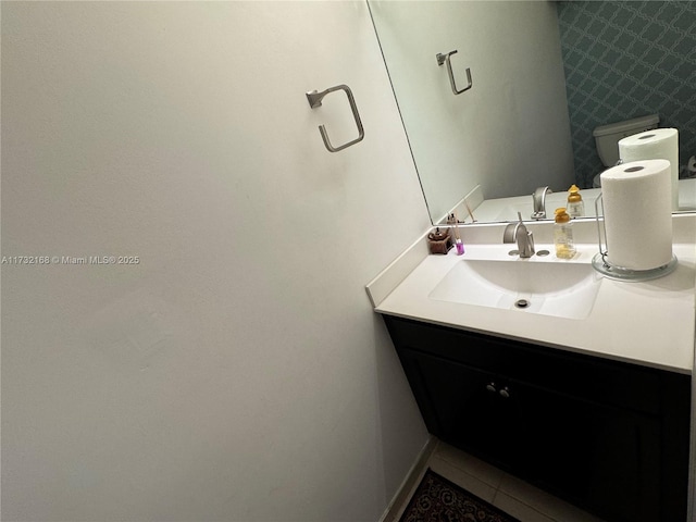 bathroom with tile patterned flooring, vanity, and toilet