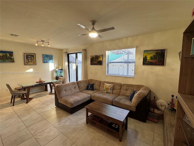 tiled living room with ceiling fan