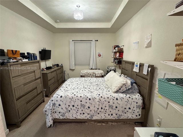 bedroom featuring light carpet and a tray ceiling