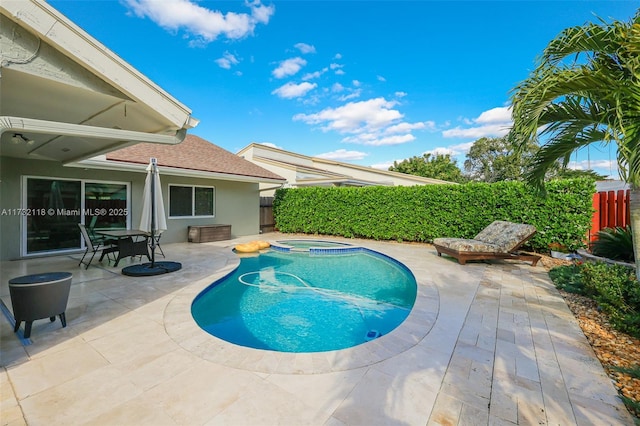 view of swimming pool featuring an in ground hot tub and a patio