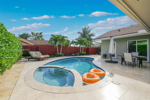 view of swimming pool featuring a patio and an in ground hot tub