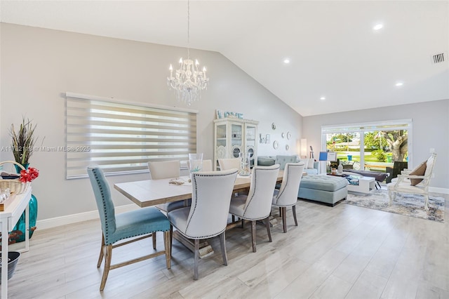 dining room featuring lofted ceiling, a chandelier, and light hardwood / wood-style flooring