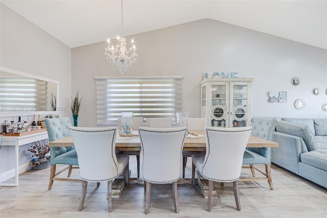 dining area with high vaulted ceiling and a notable chandelier