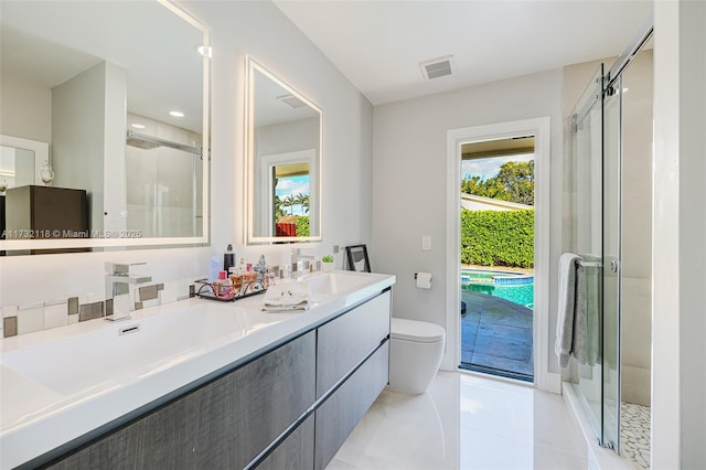 bathroom featuring vanity, toilet, a shower with shower door, and tile patterned flooring