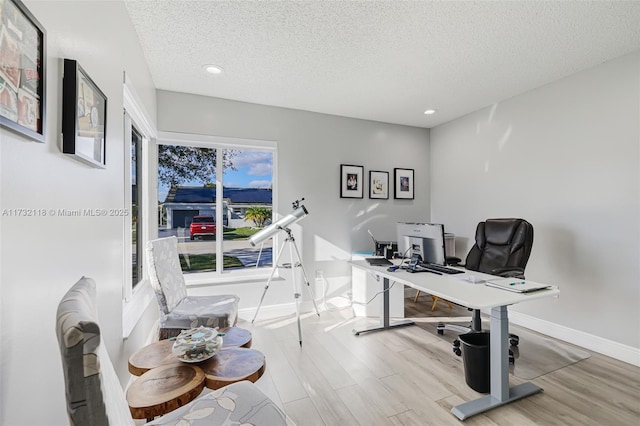 office area featuring light hardwood / wood-style floors and a textured ceiling