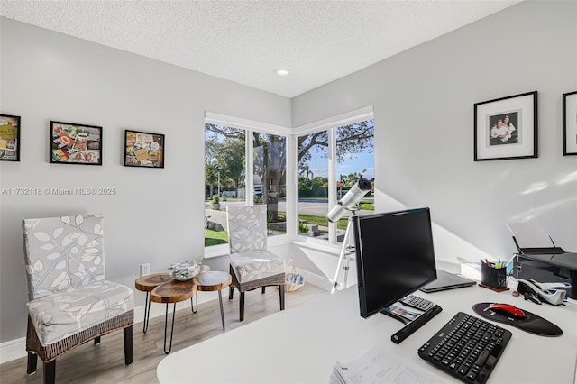 office space with a textured ceiling and light wood-type flooring