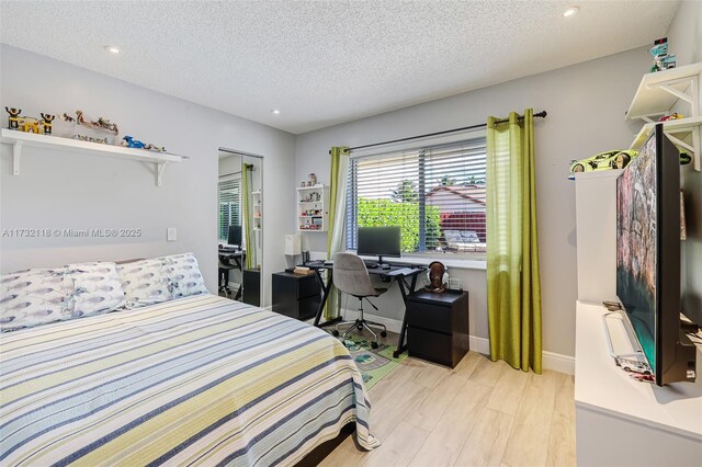 bedroom with a textured ceiling and light wood-type flooring