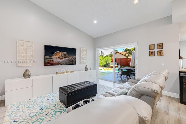 living room featuring vaulted ceiling and light hardwood / wood-style floors