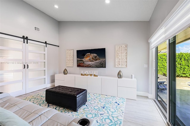 living room featuring a barn door and light hardwood / wood-style flooring