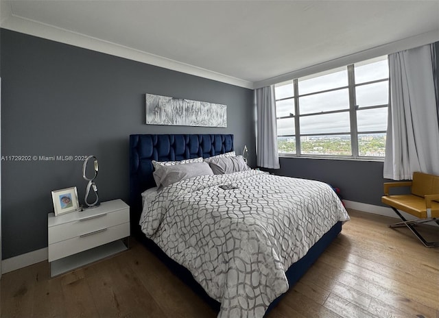 bedroom with crown molding and hardwood / wood-style flooring