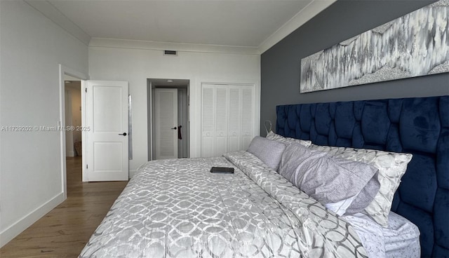 bedroom featuring ornamental molding, hardwood / wood-style floors, and a closet