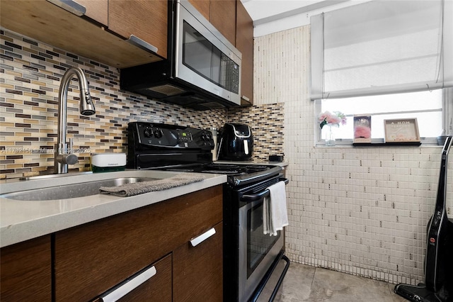 kitchen featuring dark brown cabinetry, sink, decorative backsplash, and range with electric stovetop