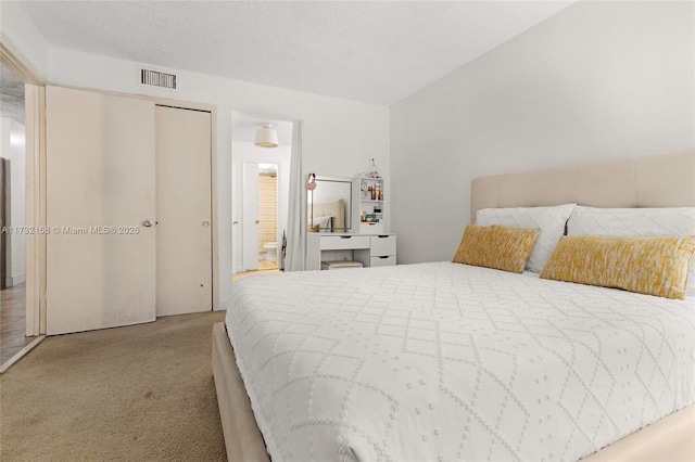 bedroom with light colored carpet, a closet, and a textured ceiling