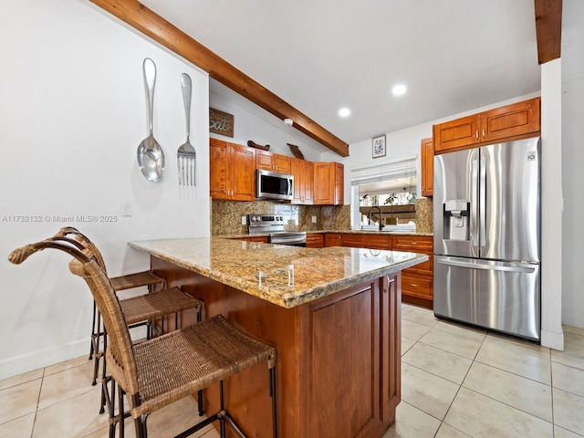 kitchen featuring a breakfast bar, tasteful backsplash, light stone counters, kitchen peninsula, and stainless steel appliances