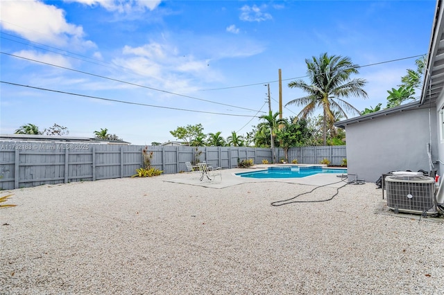 view of swimming pool with cooling unit and a patio area