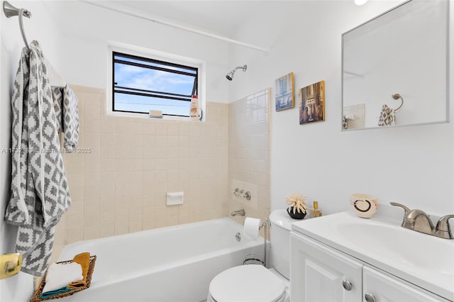 full bathroom featuring vanity, tiled shower / bath, and toilet