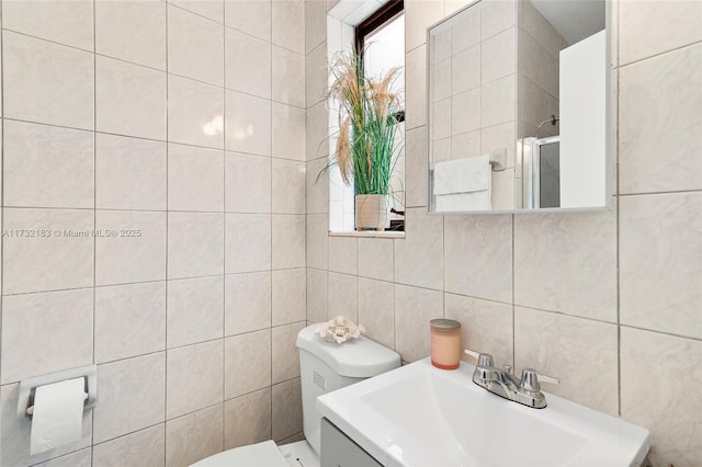 bathroom featuring toilet, sink, and tile walls