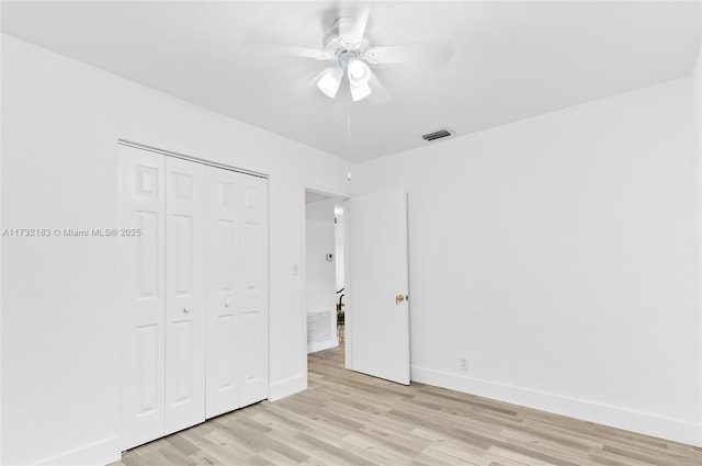 unfurnished bedroom with light hardwood / wood-style flooring, ceiling fan, and a closet