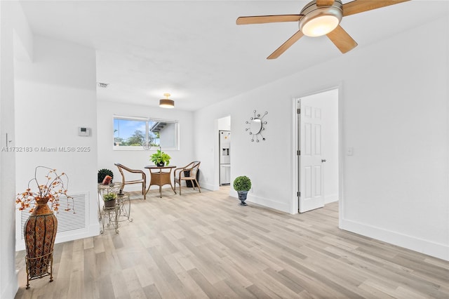 living area with ceiling fan and light hardwood / wood-style floors