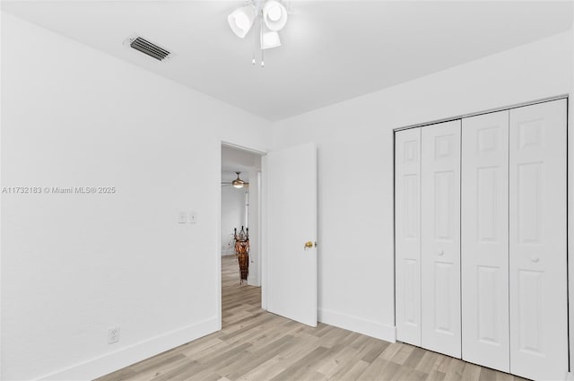 unfurnished bedroom with ceiling fan, a closet, and light hardwood / wood-style flooring