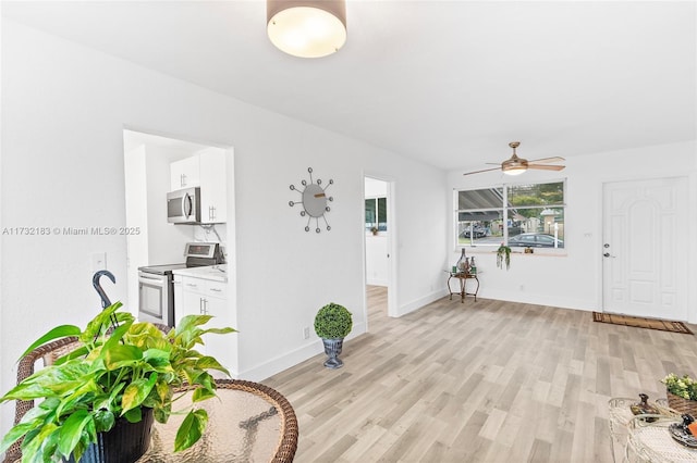 foyer with ceiling fan and light hardwood / wood-style floors