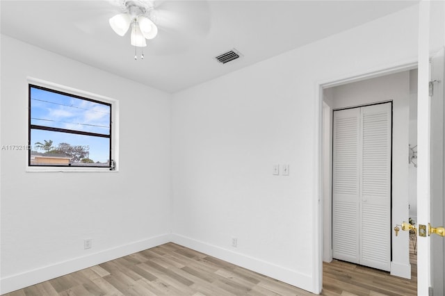 unfurnished bedroom with light hardwood / wood-style floors, a closet, and ceiling fan