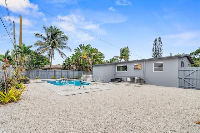 view of pool with cooling unit and a patio area